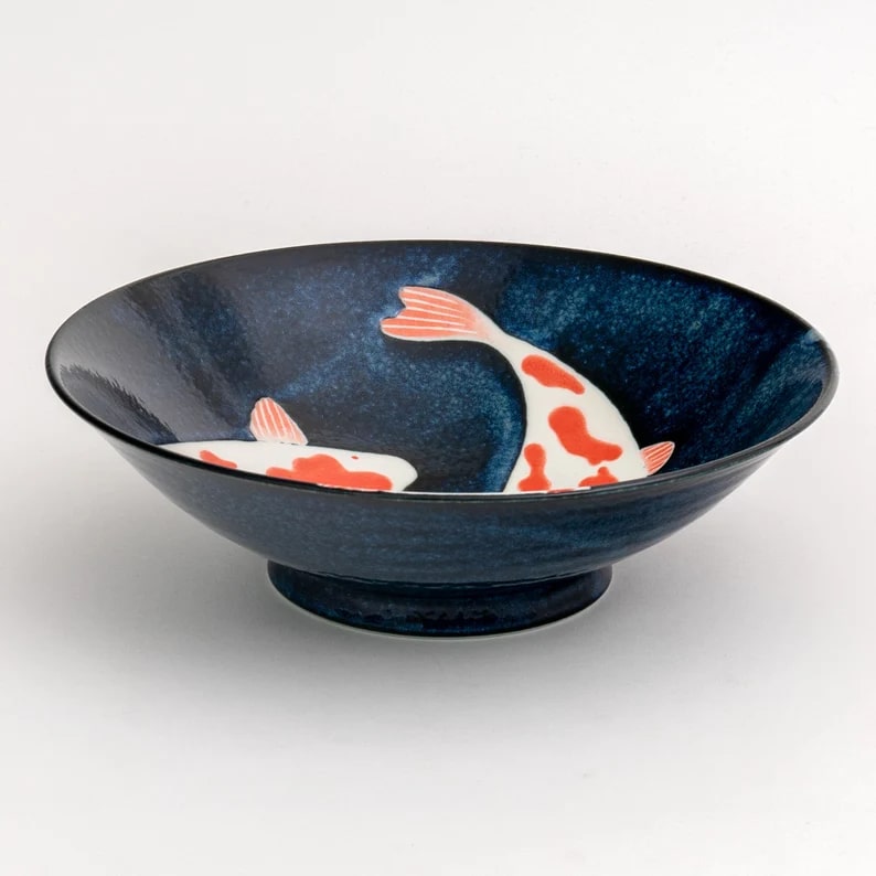 Ceramic dinnerware featuring koi fish patterns in navy blue.
