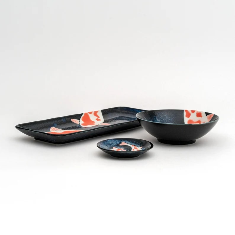 Ceramic dinnerware featuring koi fish patterns in navy blue.
