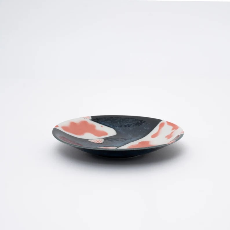 Ceramic dinnerware featuring koi fish patterns in navy blue.
