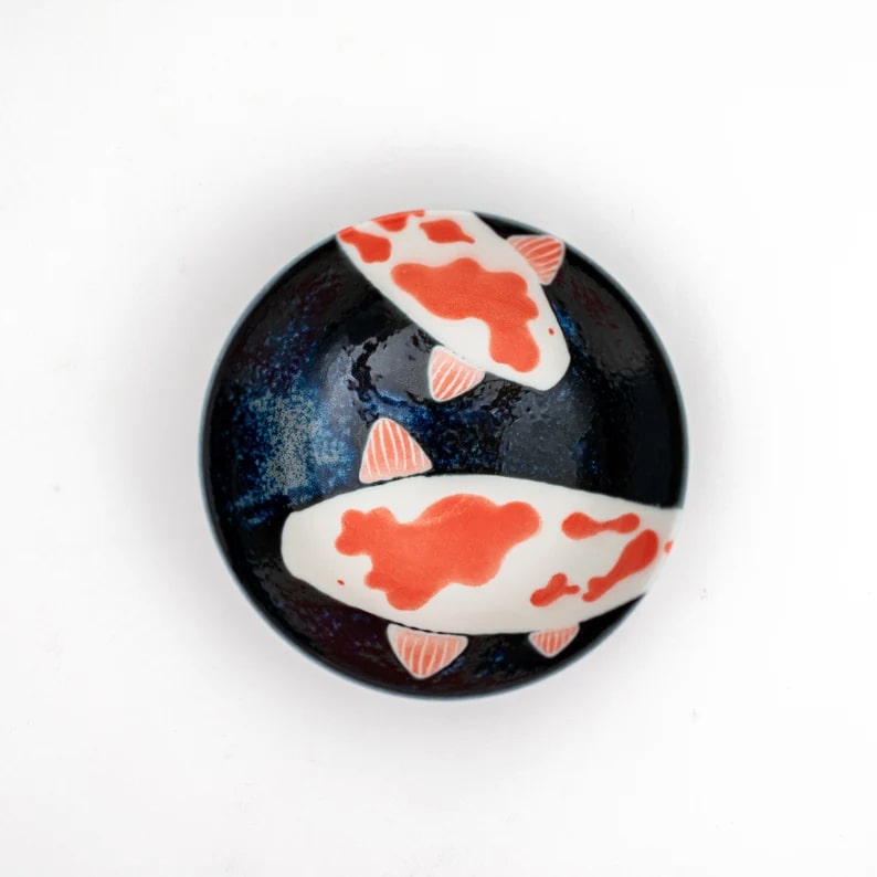 Ceramic dinnerware featuring koi fish patterns in navy blue.
