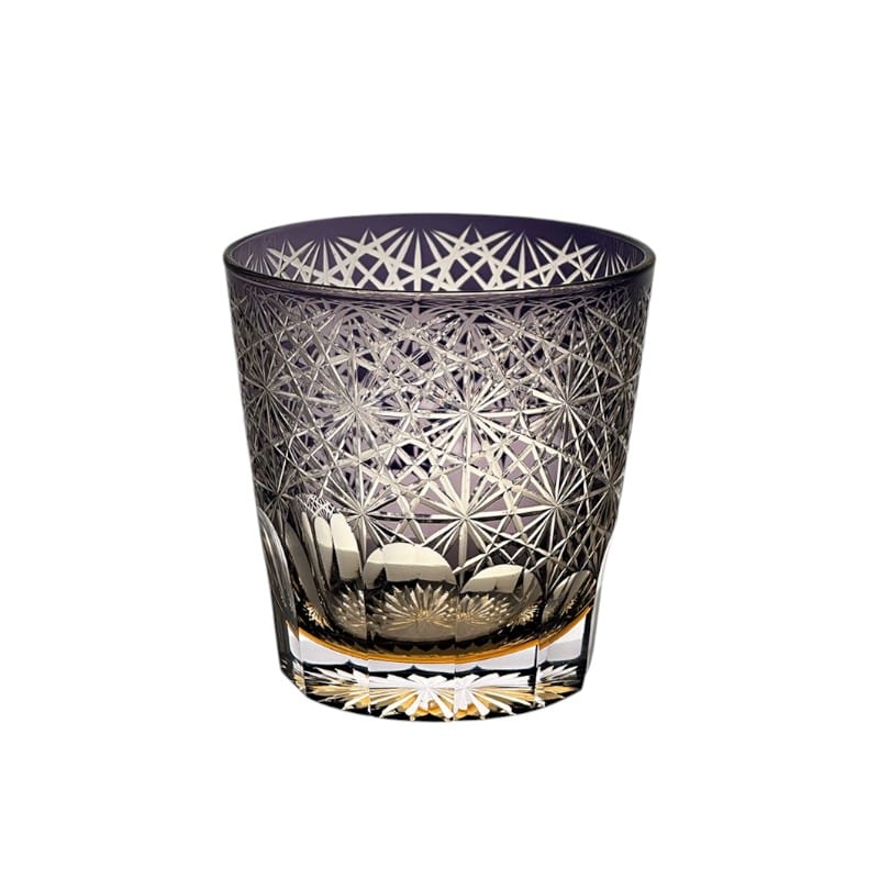 Close-up of handcrafted purple whiskey glass showcasing intricate Edo Kiriko daisy design.
