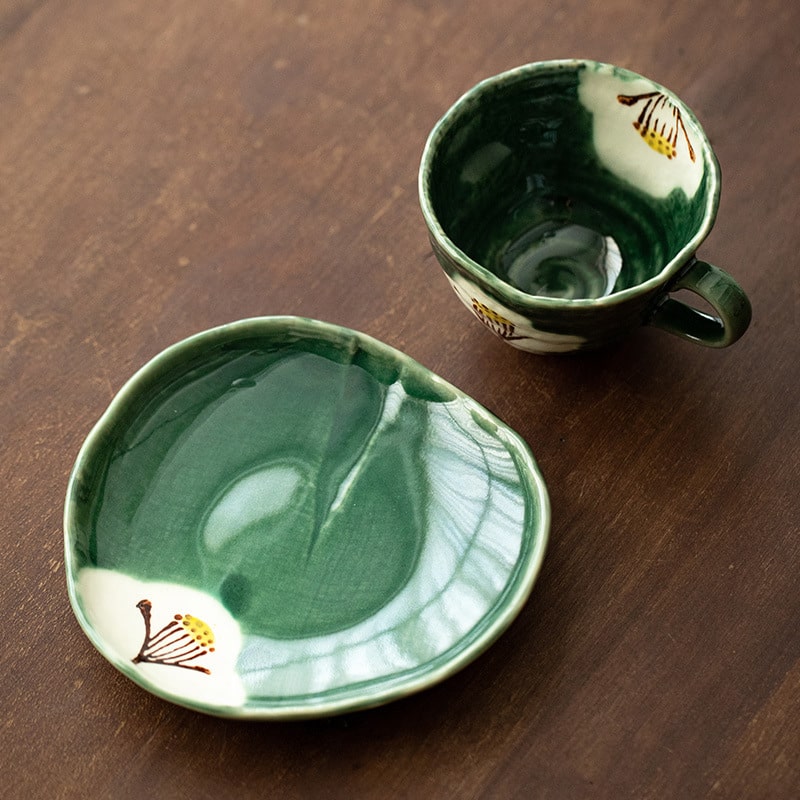 Elegant ceramic cup and saucer with hand-painted floral accents