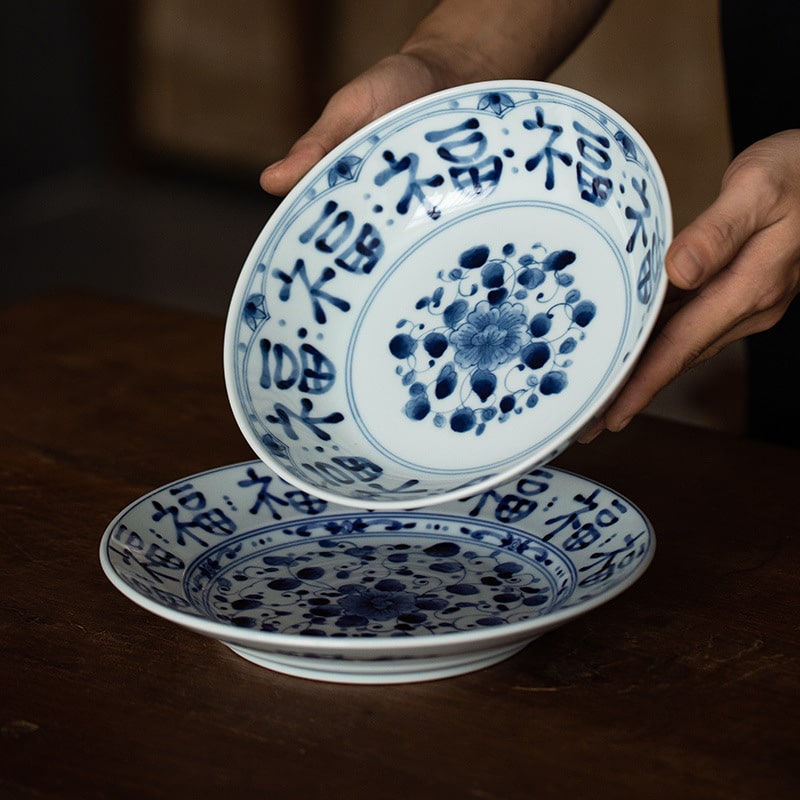 Traditional ceramic plates stacked on a wooden dining table