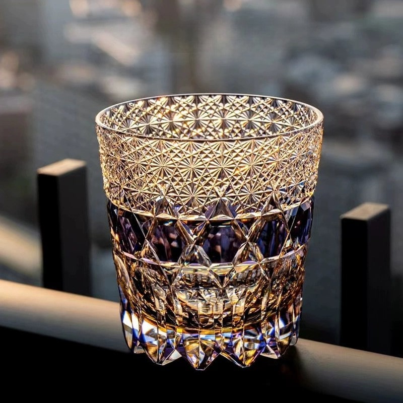 Close-up of handcrafted crystal whiskey glass in purple, showcasing intricate Edo Kiriko carving.
