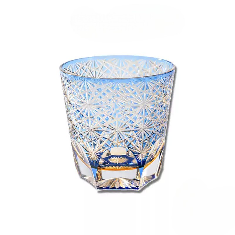 Close-up of intricate chrysanthemum pattern on a blue Edo Kiriko crystal whiskey glass.
