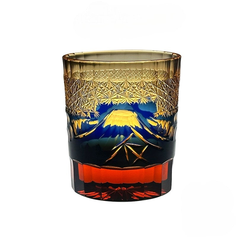 Close-up of Japanese crystal whiskey glass featuring intricate Mount Fuji and palace details in blue and green.
