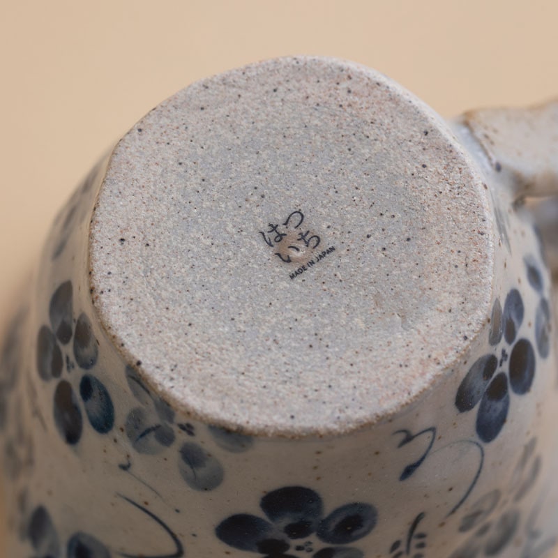 Traditional ceramic teapot and teacup set with floral designs on a wooden table