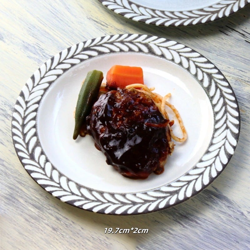 Set of leaf-bordered ceramic plates displayed for dining decor