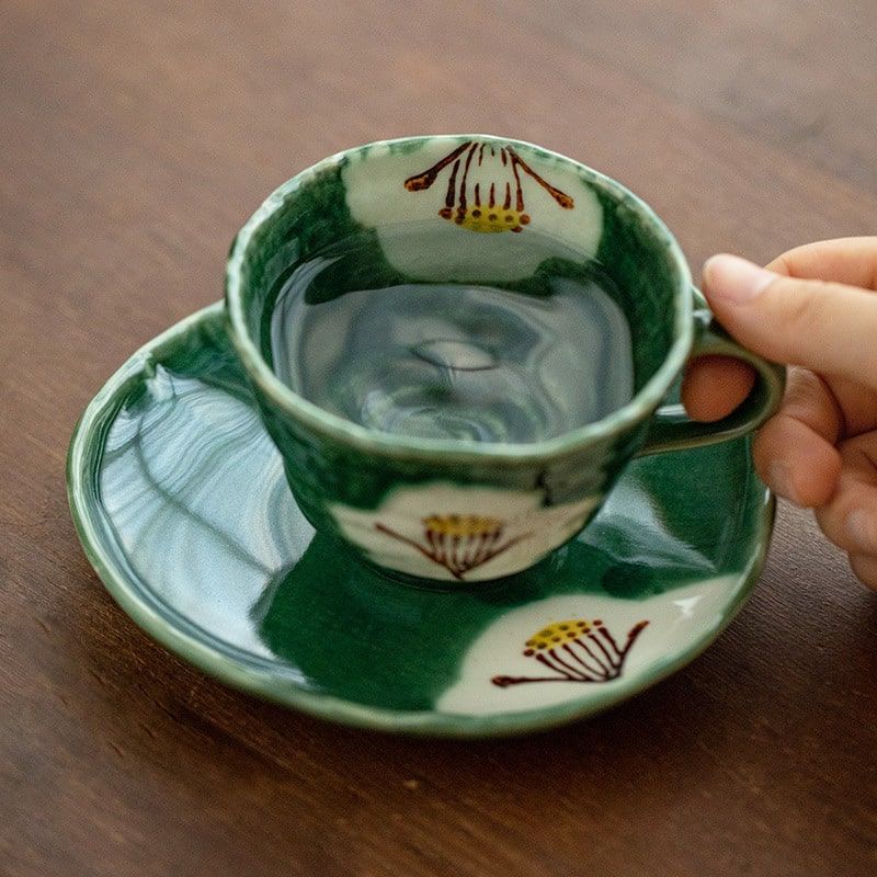 Handcrafted green ceramic cup and saucer set with floral design