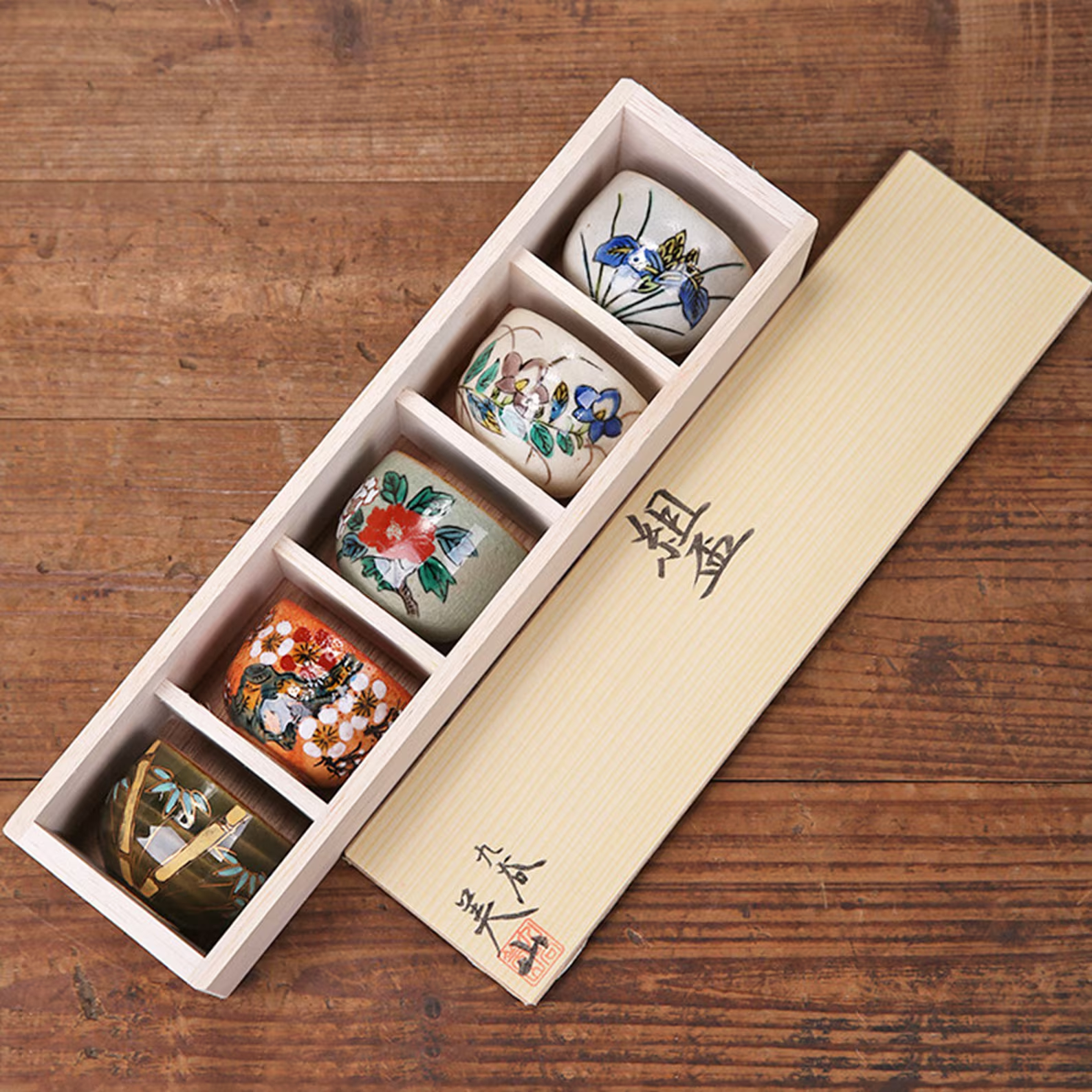 Japanese sake cup collection showcasing floral artistry.
