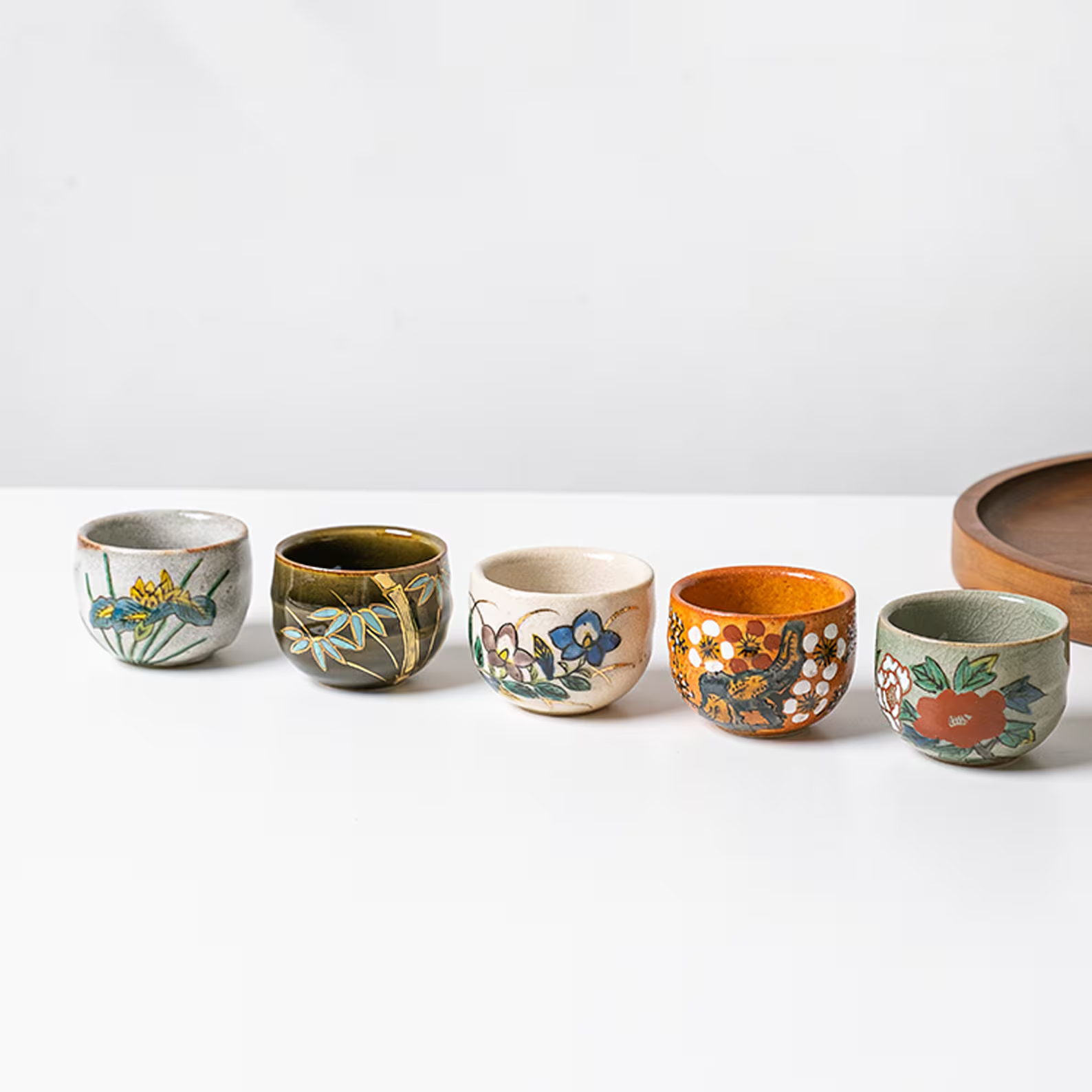 Vibrant ceramic sake cups with unique hand-painted designs.
