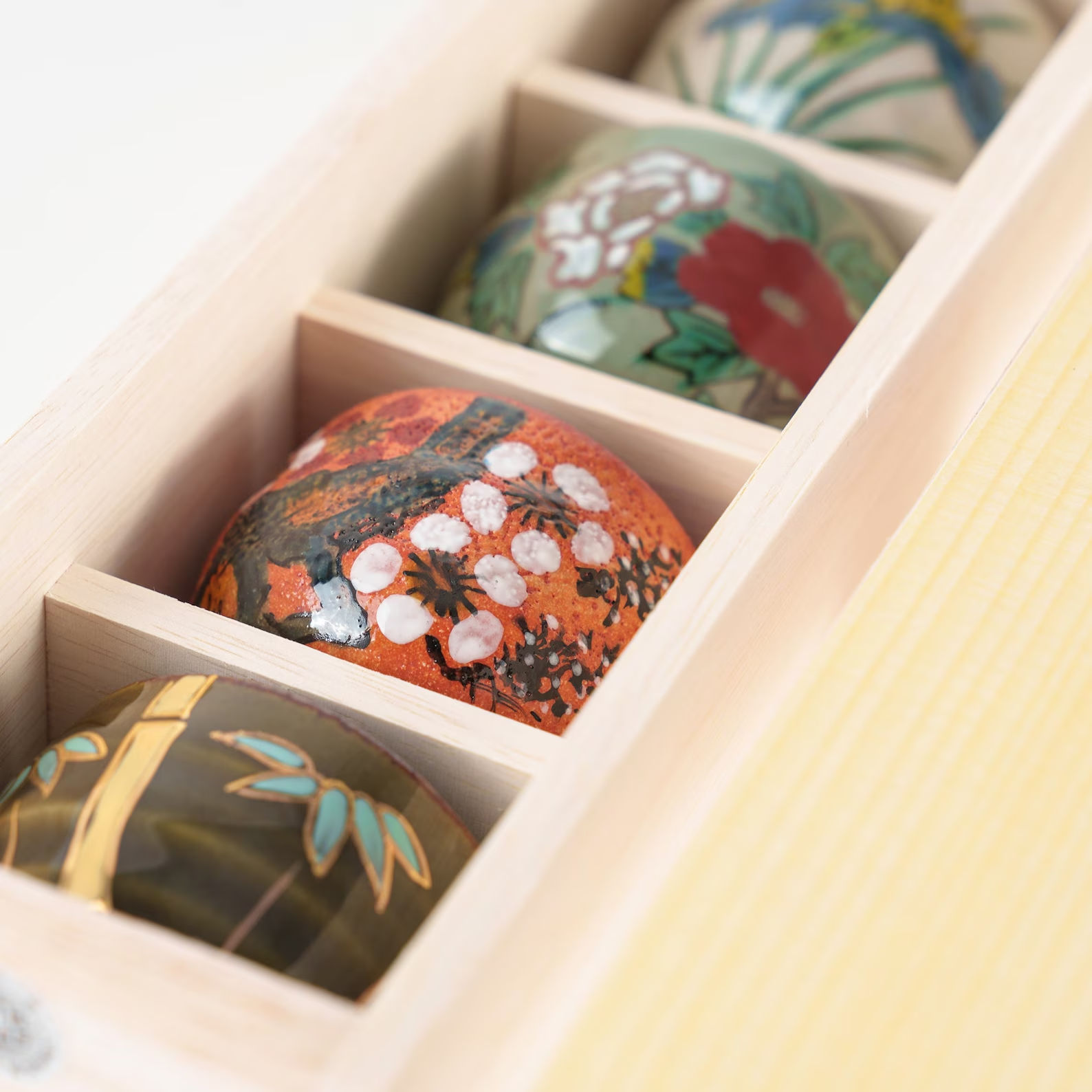 Vibrant ceramic sake cups with unique hand-painted designs.
