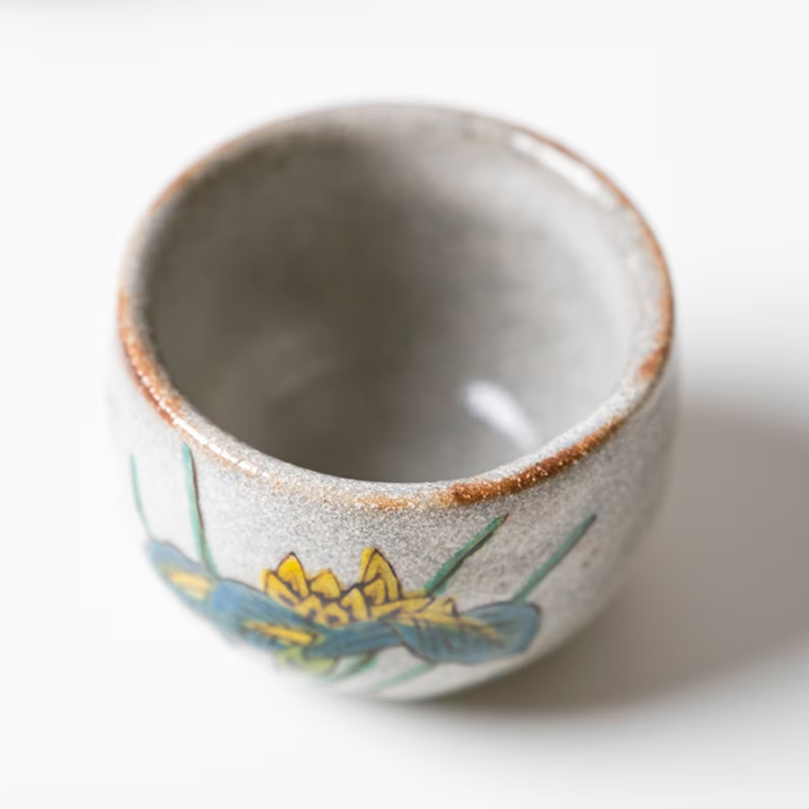 Traditional Japanese sake cups with nature-inspired artwork.
