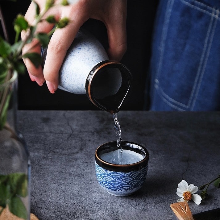 Japanese ceramic sake set with blue wave patterns.
