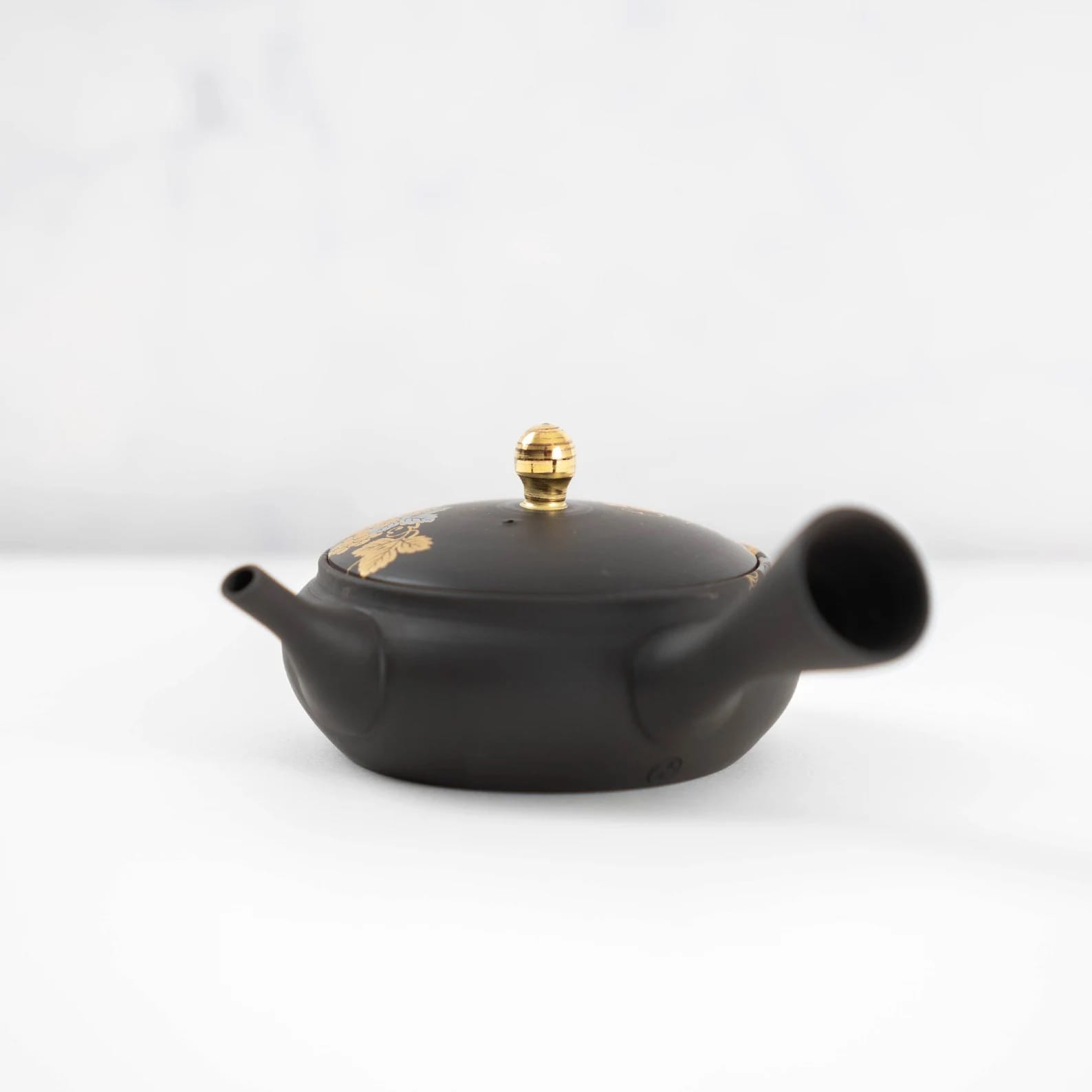 Dark-hued teapot featuring gold and floral patterns for tea and sake