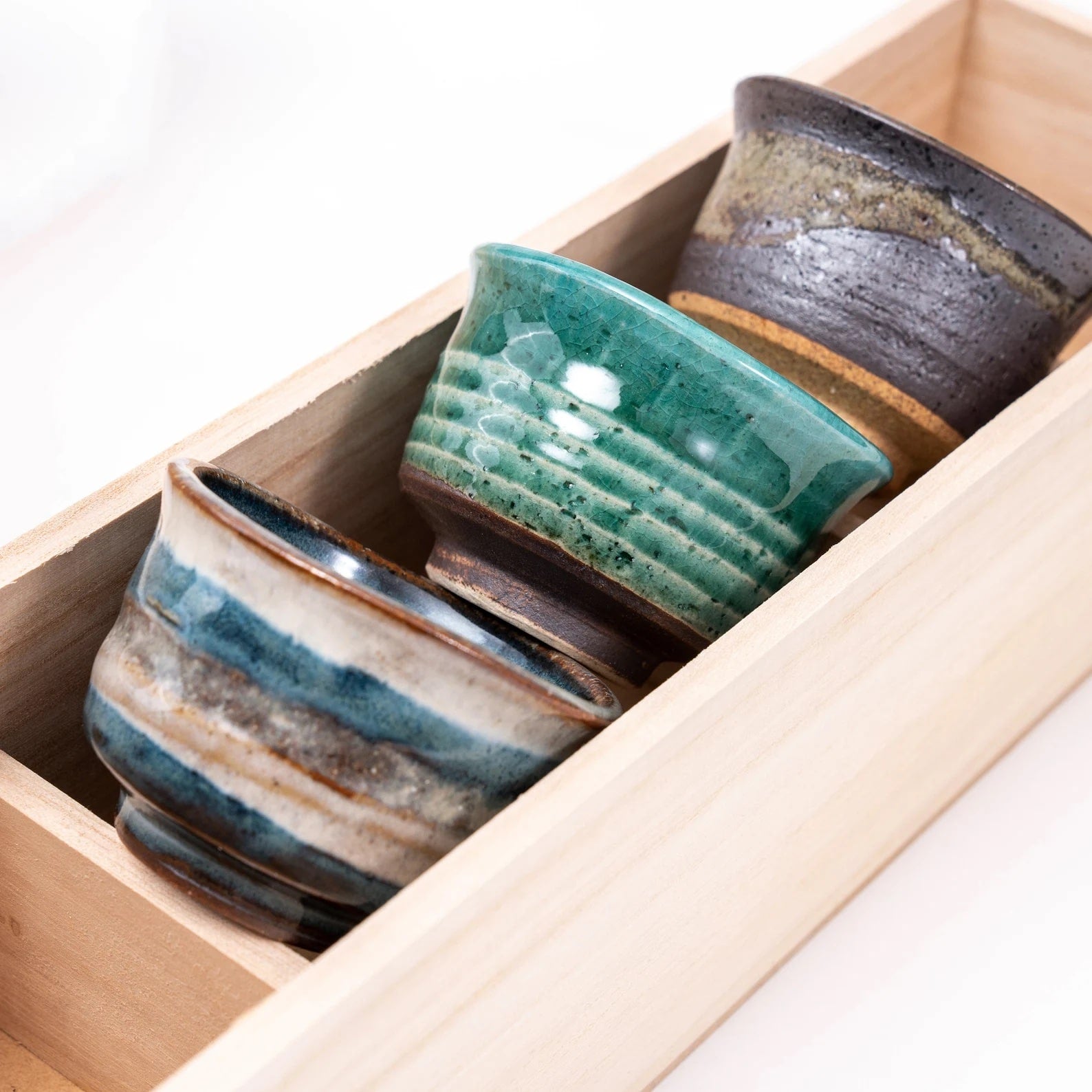 Set of six ceramic sake cups with artistic glazing in wooden box