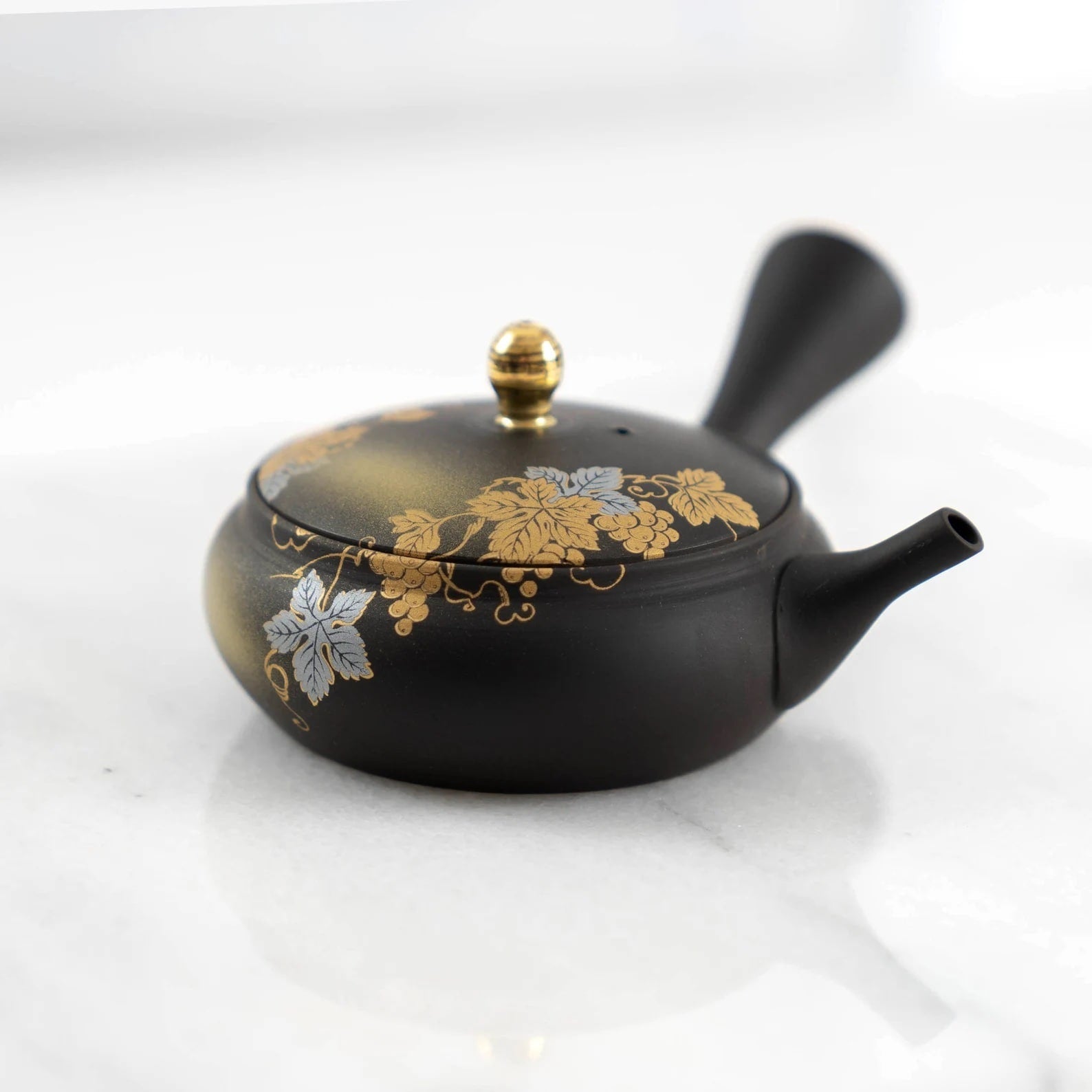 Floral teapot and sake cup set arranged on a wooden tray