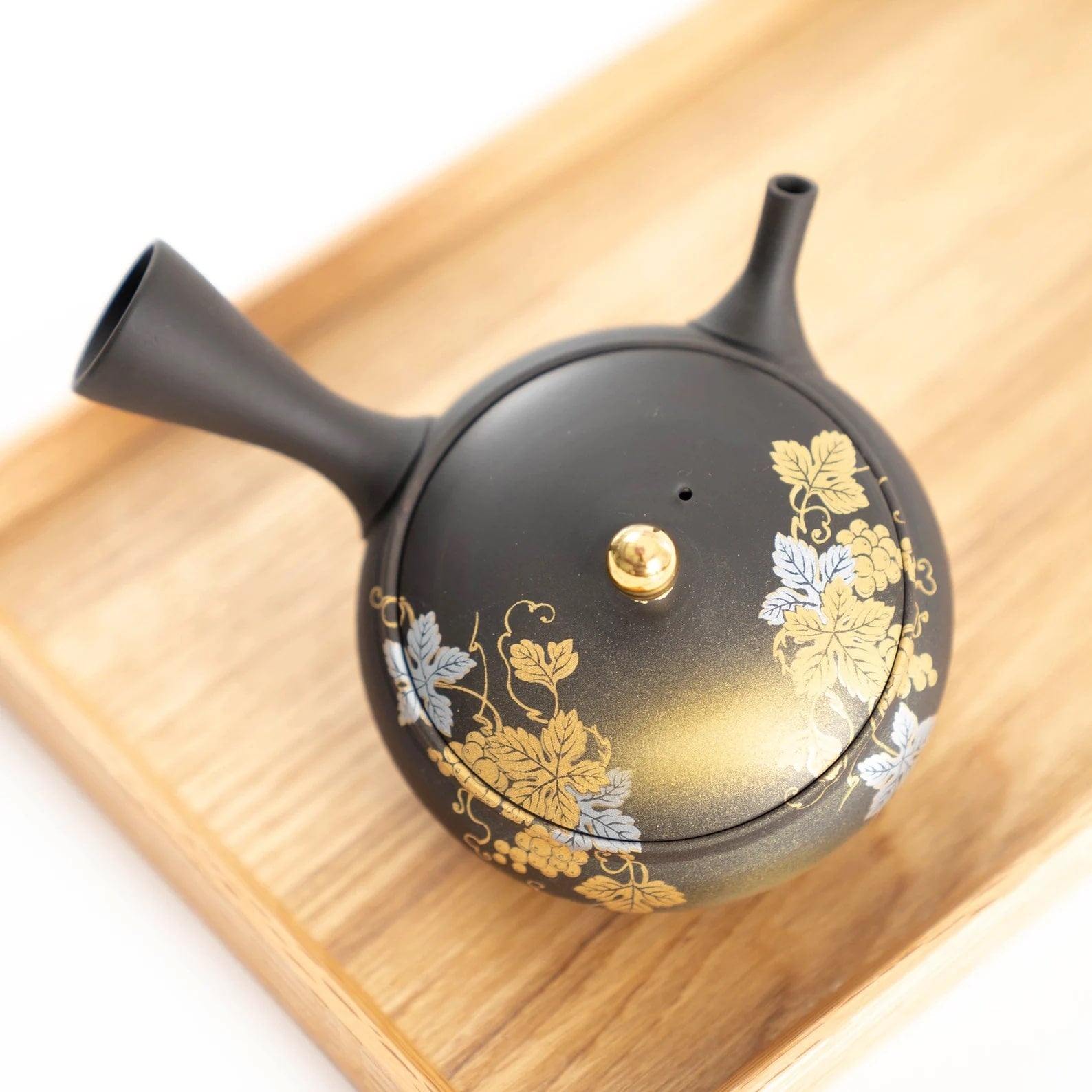 Floral teapot and sake cup set arranged on a wooden tray