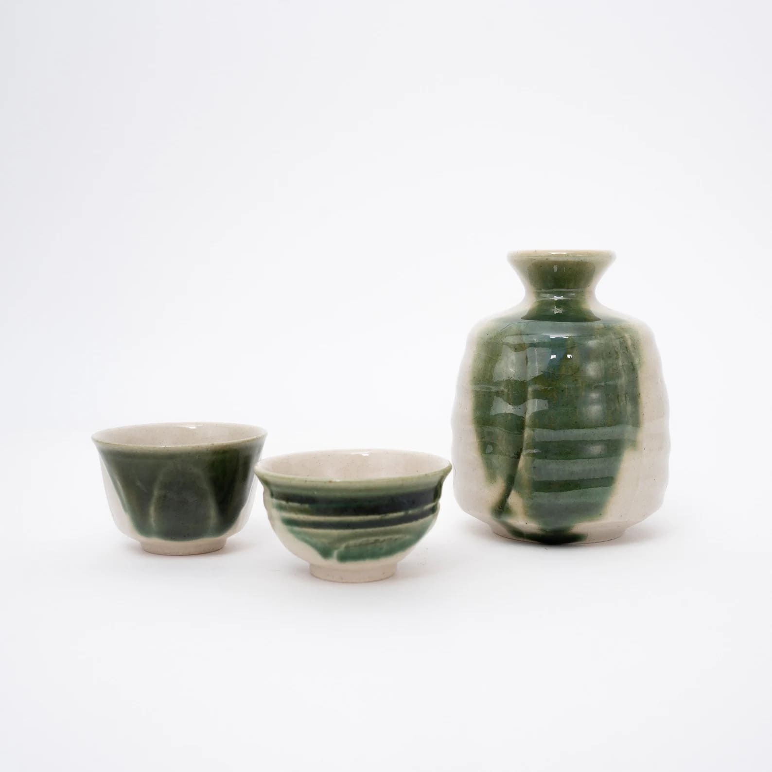 Two sake cups paired with a matching sake carafe on a wooden tray