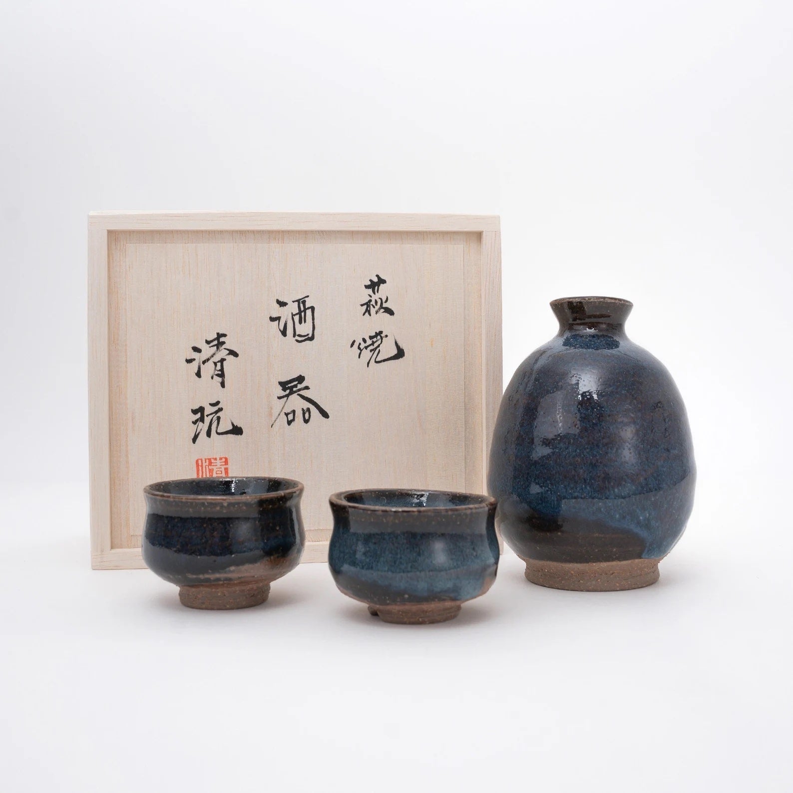 Handcrafted ceramic sake set with rich, earthy glaze in wooden box