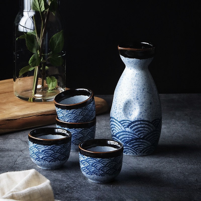 Japanese ceramic sake set with blue wave patterns.
