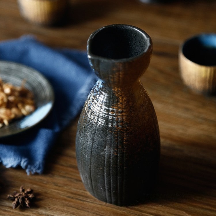 Close-up of handcrafted sake cup with a matte finish and rugged texture.
