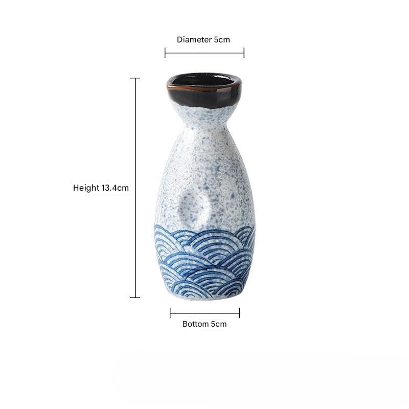 Handcrafted ceramic sake set showcasing wave-patterned cups and bottle.
